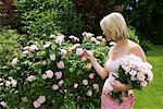 Woman looking at roses in garden