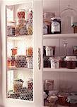 Pots of peach and raspberry jam in cupboard