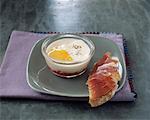 Coodled egg with raw ham on a slice of bread