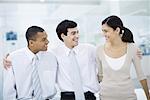 Three professionals with arms around each other's shoulders, smiling, portrait