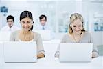 Telemarketers working in call center, smiling