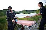 Agent de police et les ambulanciers paramédicaux avec sac mortuaire, Toronto, Ontario, Canada