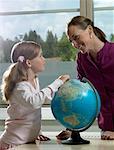 Enseignant et une fille avec un globe terrestre