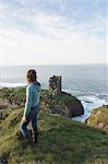 Frau, stehend auf einer Klippe von Dun eine Oir Schloss, Cape Clear Island, County Cork, Irland