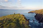 Femme debout sur la falaise par la mer celtique, Cape Clear Island, comté de Cork, Irlande