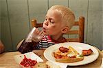 Boy Eating Fish and Chips and Drinking a Soda