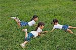 Three girls lying on grass in a park
