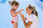 Mother Applying Sunscreen on Daughter