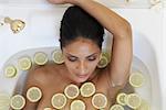 Femme dans la baignoire avec des tranches de citron vert