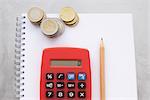 Calculator, Pencil, Pad of Paper and Stacks of Coins