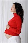 Profile of pregnant woman with hands on stomach