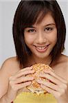 Jeune femme mangeant burger