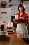 Waitress in diner serving burger and drink