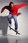 young man wearing red hooded sweatshirt on skateboard