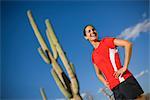 Frau stehend vor ein Saguaro-Kaktus, Tucson, Arizona, USA