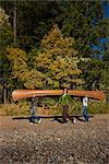 Three Women Carrying Canoe in the Forest