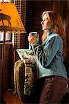 Femme avec une tasse de cacao en regardant par la fenêtre de la cabine