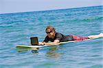 Man surfing and using a laptop