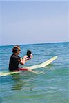 Homme surf et à l'aide d'un ordinateur portable