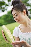 Young woman holding sweet corn