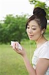 Japanische Frau, hören Musik und holding Karten
