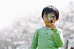 Japanese boy looking through magnifying glass