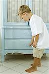 Little boy peeking into drawer