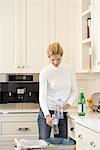 Woman Recycling Bottles in Kitchen