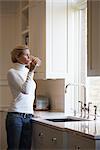 Woman Filling Glass from Kitchen Faucet