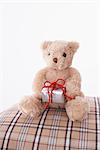 Teddybär auf Bett mit Geschenk