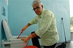 Senior man cleaning toilet