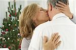 Kissing couple in front of a Christmas tree