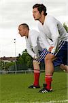 Deux jeunes footballeurs faisant des exercices de stretching, mise au point sélective