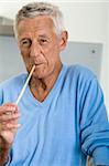 Homme Senior avec une nouille crue dans la bouche