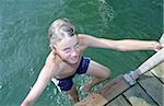 Blonde Boy climbing up a Ladder out of the Water - Swimming - Fun - Leisure Time - Youth