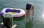 Boy jumping into Water next to his Rubber Dinghy - Lake - Leisure Time - Youth