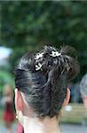 Brune avec des fleurs dans son goupillé vers le haut de cheveux - coiffure - mariée - mariée