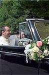 Mariée et le marié sur la banquette arrière d'une voiture décapotable - Automobile - mariage - harmonie