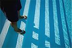 Man standing on the stairs of the swimming pool