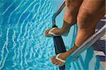 Man standing on the pool ladder of the swimming pool