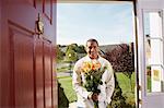 Mann in Tür mit Blumen