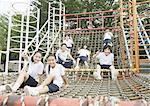 Elementary students and teacher sitting on play equipment