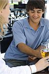 Young man sitting at outdoor cafe with friend