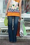 Junge Frau Schaufensterbummel, tragen mehrere Einkaufstaschen, beschnitten Rückansicht