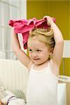 Little girl holding shirt over her head