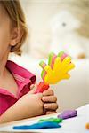 Little girl holding plastic clapping toy, cropped view