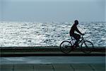 Man Fahrradfahren durch den Park am Wasser