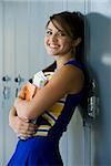 Cheerleader standing against lockers.