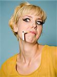 femme avec une cigarette cassée dans sa bouche