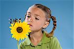 Child looking at a flower and a dragonfly.